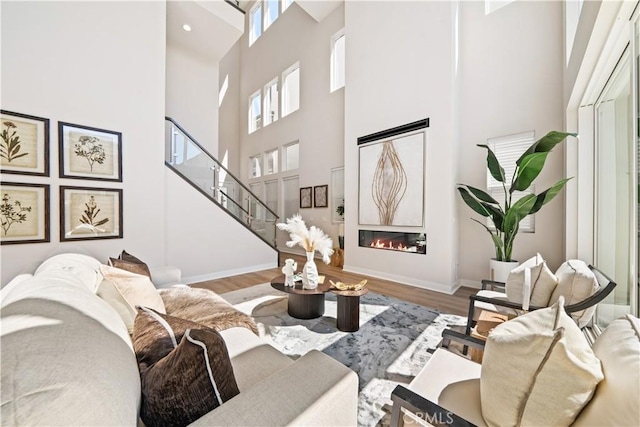 living room with hardwood / wood-style flooring and a towering ceiling