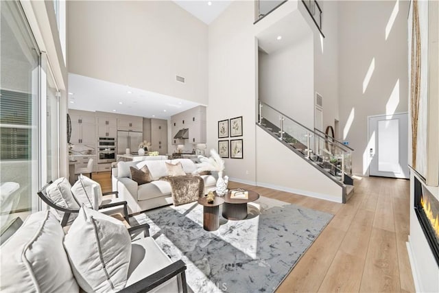 living room featuring a high ceiling and light hardwood / wood-style flooring