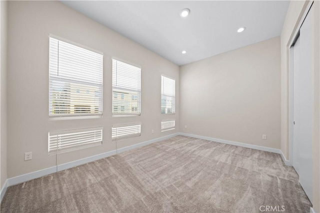 unfurnished room with light colored carpet and a healthy amount of sunlight