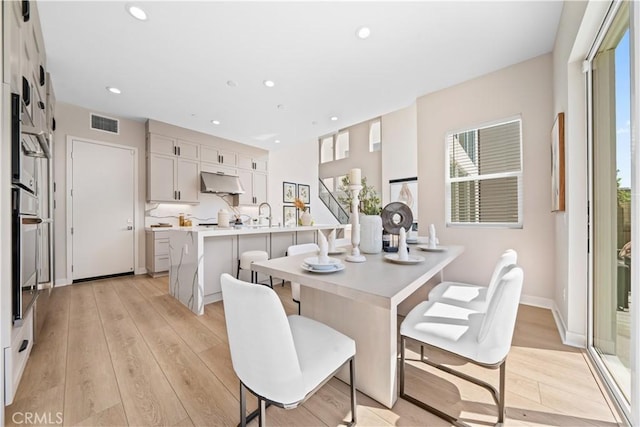 dining space featuring sink and light hardwood / wood-style flooring