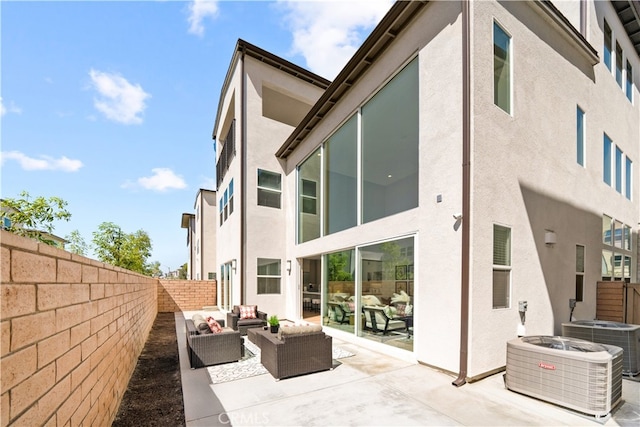 back of property with central air condition unit, a patio area, and an outdoor hangout area