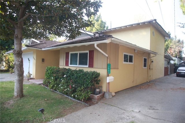 view of side of property with a lawn and a garage