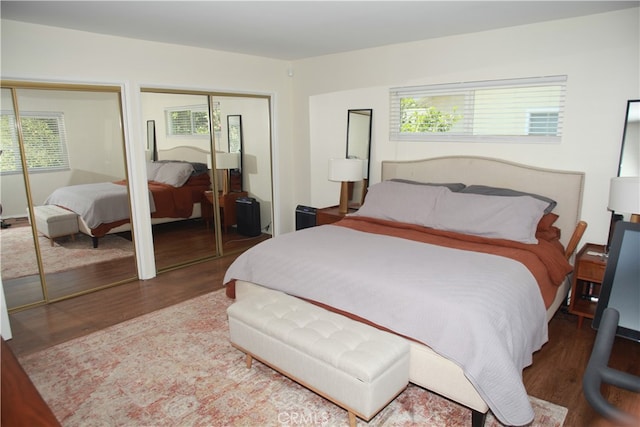 bedroom featuring hardwood / wood-style flooring and two closets