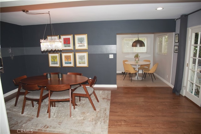 dining area featuring wood-type flooring, a notable chandelier, and a wealth of natural light