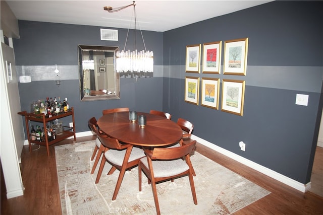 dining space with a chandelier and hardwood / wood-style floors