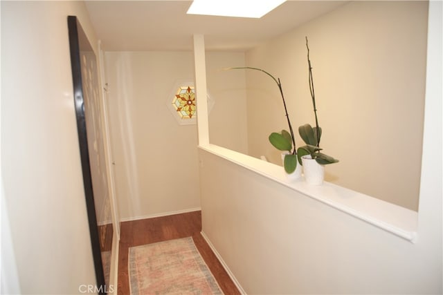 hall featuring a skylight and hardwood / wood-style flooring