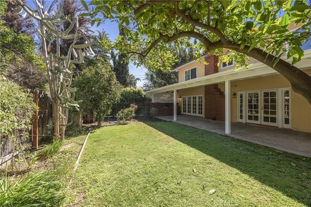 view of yard featuring a fenced backyard, a patio, and french doors