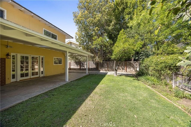 view of yard featuring fence, a patio area, and french doors