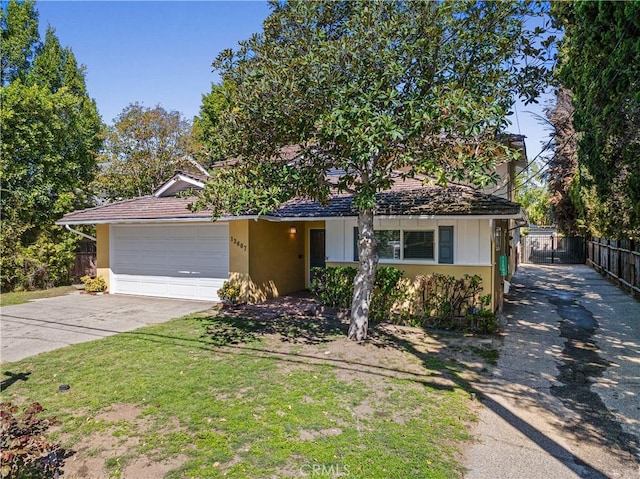 view of front of property with a garage, stucco siding, driveway, and fence