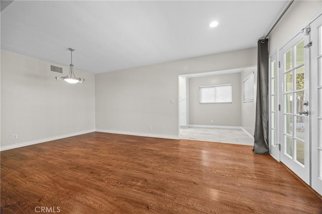 unfurnished room featuring recessed lighting, wood finished floors, visible vents, and baseboards