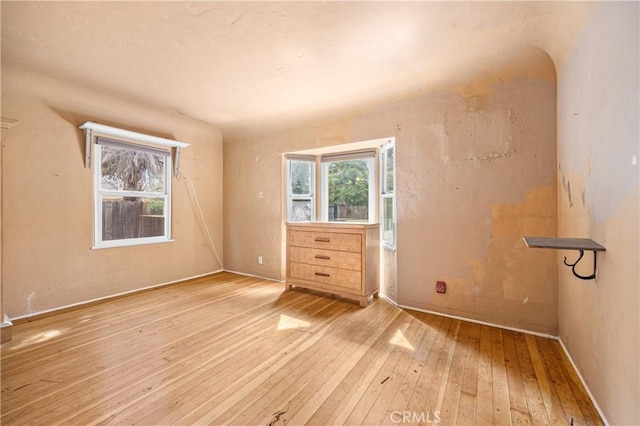 spare room with hardwood / wood-style floors and baseboards