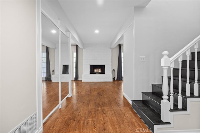 hallway with baseboards, wood finished floors, recessed lighting, and stairway