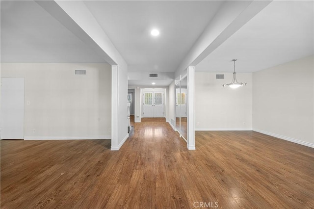 interior space featuring baseboards, wood finished floors, and visible vents