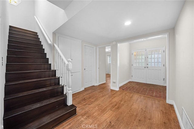 foyer entrance featuring stairway, light wood-style floors, baseboards, visible vents, and recessed lighting