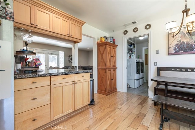 kitchen with light wood-type flooring, pendant lighting, light brown cabinets, and washer / clothes dryer