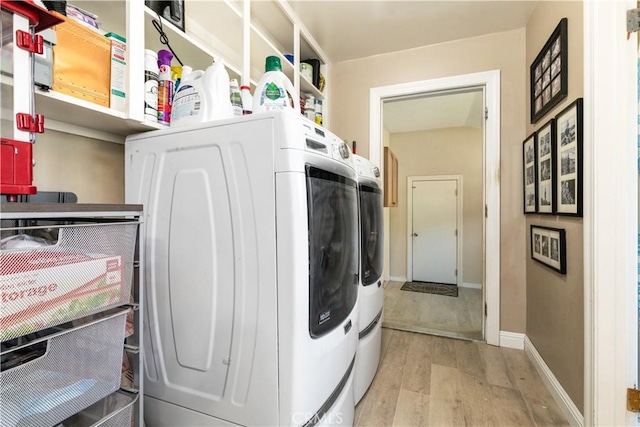 washroom featuring washer and clothes dryer and light hardwood / wood-style flooring