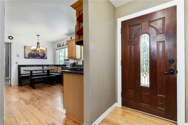 foyer entrance featuring light wood-type flooring and an inviting chandelier