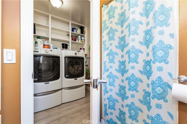 laundry room featuring washing machine and dryer and light hardwood / wood-style floors