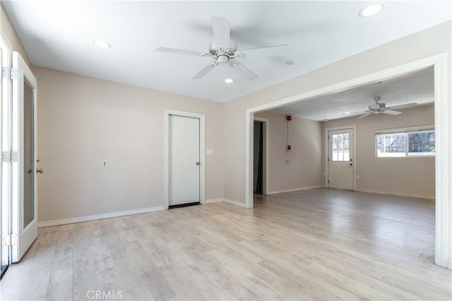 empty room with ceiling fan and light hardwood / wood-style flooring