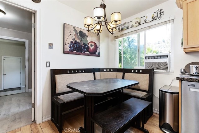 dining space with light wood-type flooring and an inviting chandelier