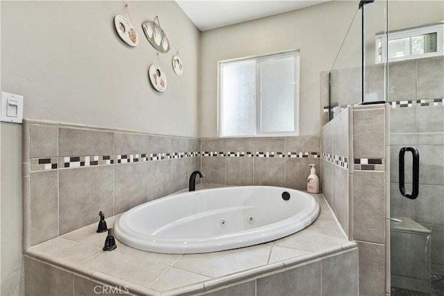 bathroom featuring independent shower and bath and a healthy amount of sunlight