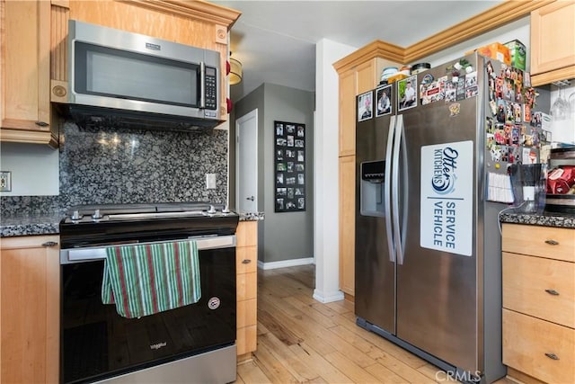 kitchen with backsplash, light brown cabinetry, appliances with stainless steel finishes, and dark stone counters