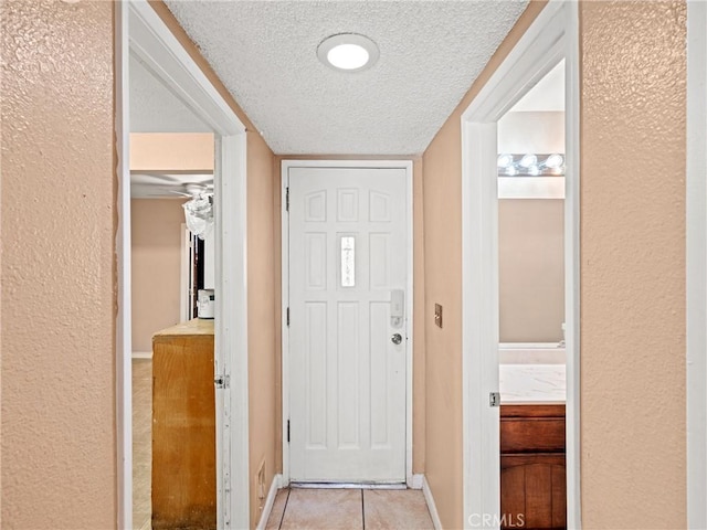 entryway featuring light tile patterned flooring and a textured ceiling