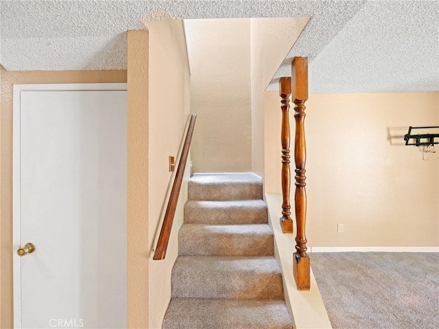 staircase with carpet and a textured ceiling