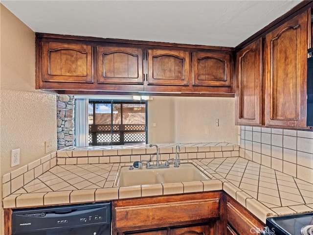 kitchen featuring sink, tile countertops, and dishwasher