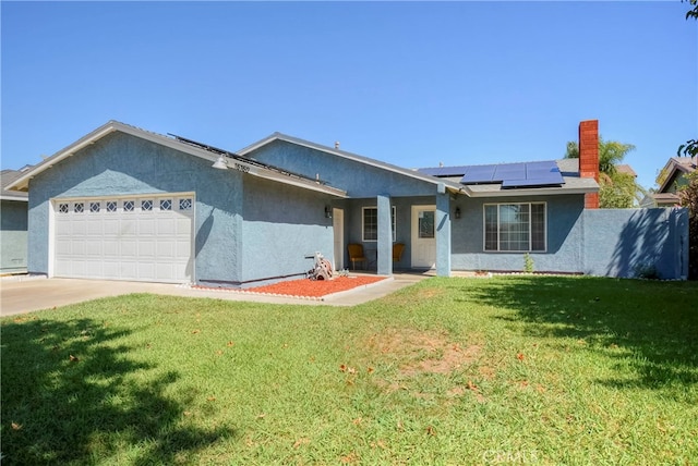 single story home featuring a front yard, solar panels, and a garage