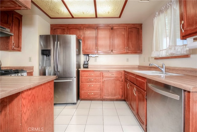 kitchen with light tile patterned flooring, sink, and stainless steel appliances