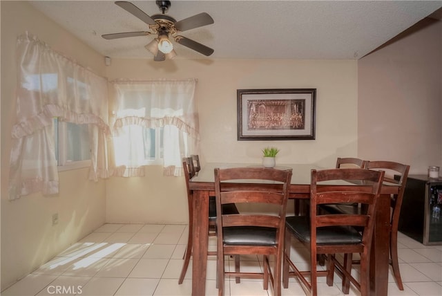 tiled dining space featuring ceiling fan and a textured ceiling