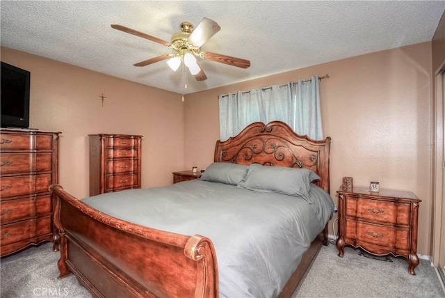 carpeted bedroom featuring ceiling fan and a textured ceiling