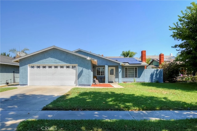 ranch-style home featuring a front yard, a garage, and solar panels