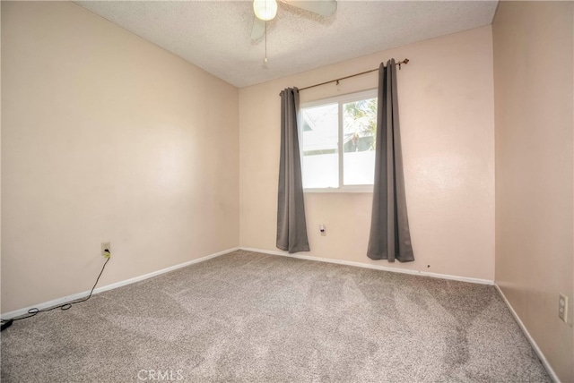 carpeted spare room with a textured ceiling and ceiling fan