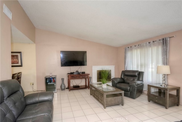 tiled living room featuring a textured ceiling, a fireplace, vaulted ceiling, and wine cooler