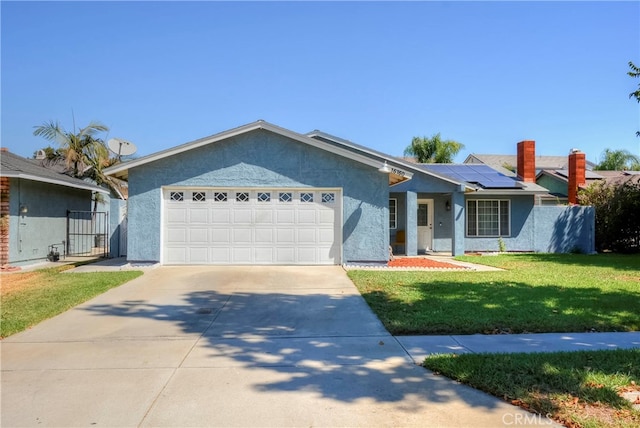 ranch-style home with a garage, solar panels, and a front lawn