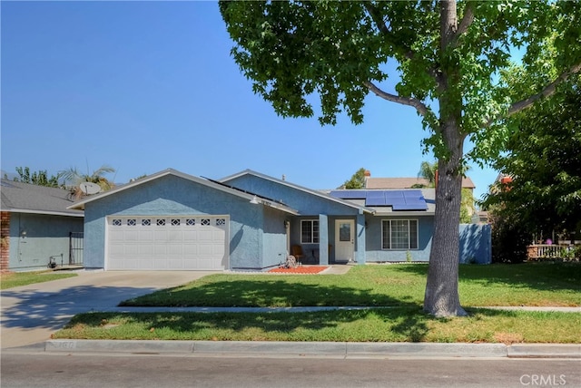 single story home featuring a garage, solar panels, and a front lawn