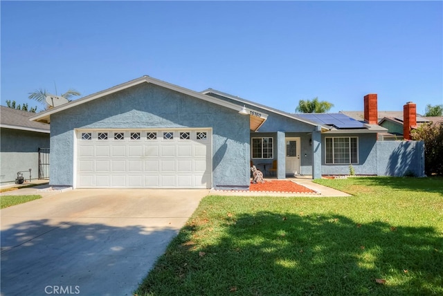 single story home with a front yard, a garage, and solar panels