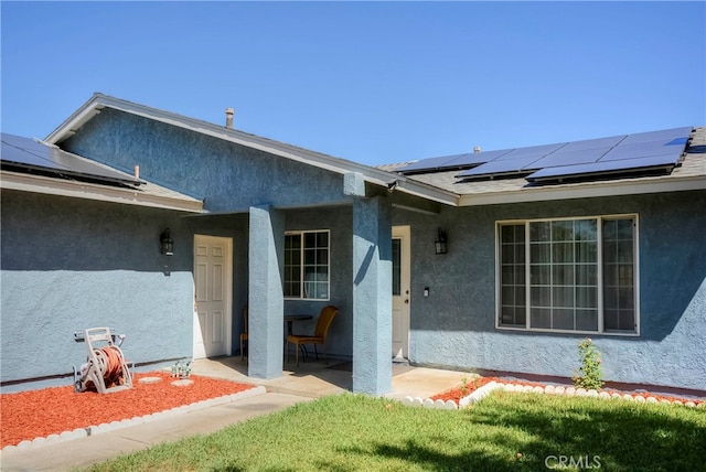 entrance to property with a patio and solar panels