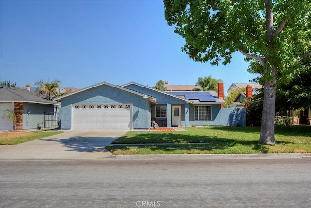 ranch-style house featuring a garage, solar panels, and a front yard