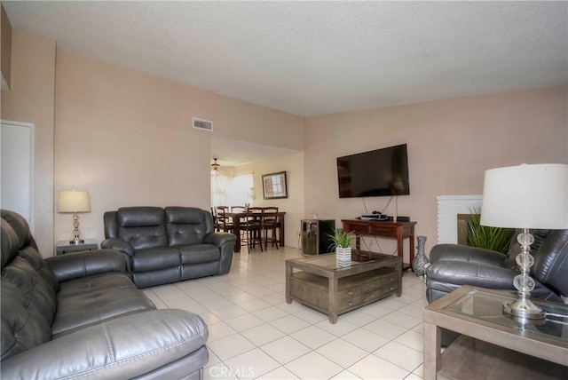 living room featuring a textured ceiling and light tile patterned floors