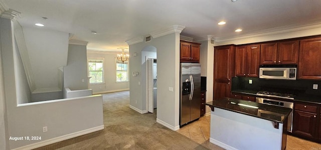 kitchen featuring stainless steel appliances, an inviting chandelier, tasteful backsplash, light tile patterned floors, and ornamental molding