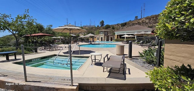 view of pool with a patio area and a community hot tub