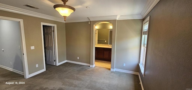 unfurnished bedroom featuring carpet floors, crown molding, and connected bathroom