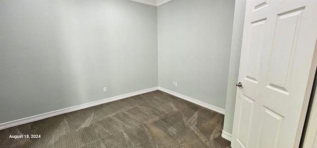 carpeted empty room featuring crown molding