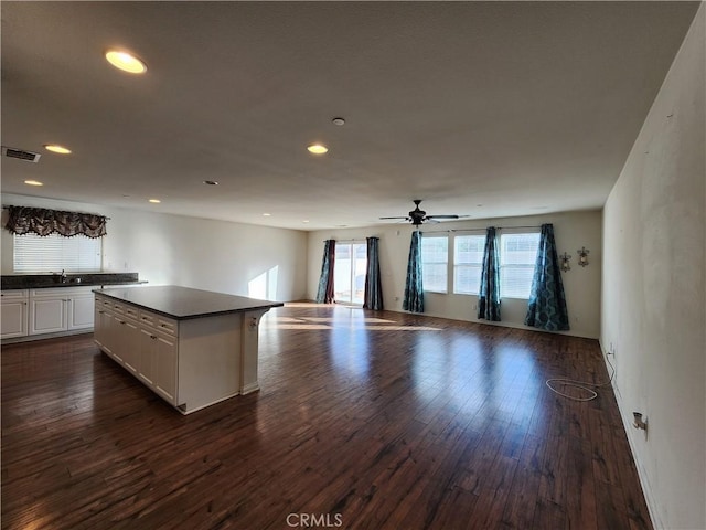 kitchen featuring ceiling fan, white cabinetry, a center island, sink, and dark hardwood / wood-style flooring