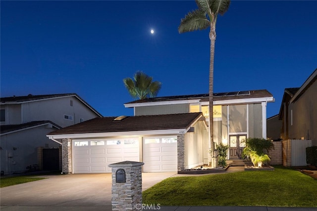 view of front of house featuring a yard and a garage