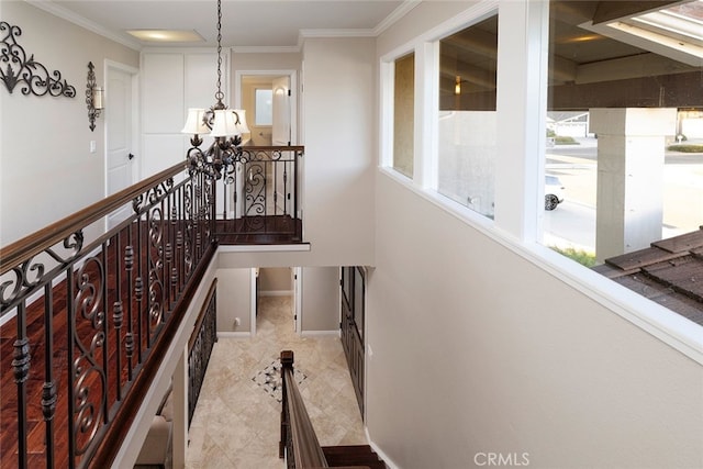 stairway with a chandelier and crown molding