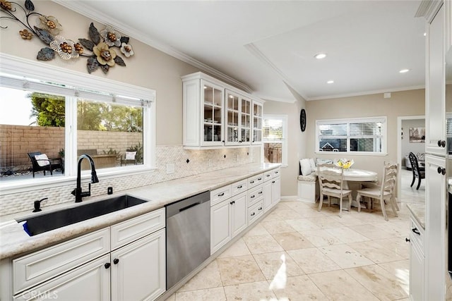 kitchen with backsplash, stainless steel dishwasher, sink, white cabinetry, and plenty of natural light